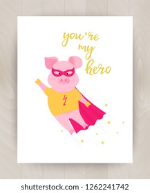 Pig superhero flies towards adventure. Hand lettering You are my hero. Motivational card for a boy on a wooden background