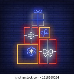 Pile of gifts neon sign. Present boxes, carton wrap, ribbon, bow. Vector illustration in neon style for topics like surprise, holiday, shopping