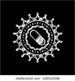pill icon inside chalk emblem written on a blackboard