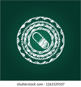 pill icon inside chalkboard emblem on black board