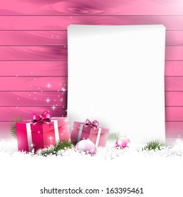 Pink Christmas background with empty paper and gift boxes in snow on wooden background