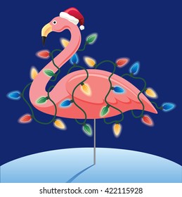 Pink Christmas Flamingo wearing Santa hat and string of Christmas lights standing in snow