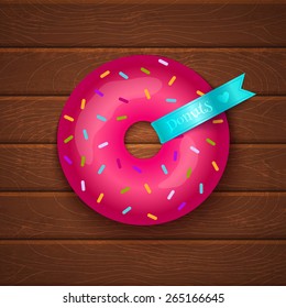 Pink donut on wooden background 