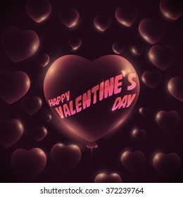 Pink glossy balloon with heart shape and glows with Valentine's Day text and others balloons around.