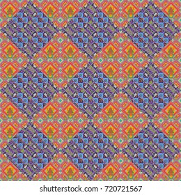 Pink, green and violet ethnic geometric motif seamless pattern in pink, green and violet on abstract background.