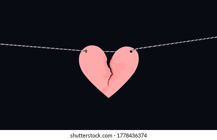 Pink heart shaped paper with torn marks hanging on the rope. Broken heart,unrequited love.