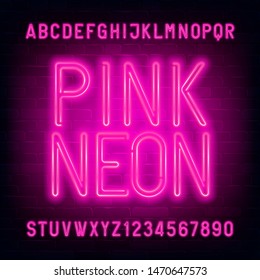 Pink Neon alphabet font. Light bulb letters and numbers on brick wall background. Stock vector typescript for your typography design.
