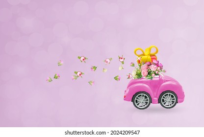 Pink retro car with a gift box on the roof and flowers on a pink background. Vector