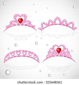 Pink tiaras with diamonds and faceted red stones in a heart shape isolated on white background