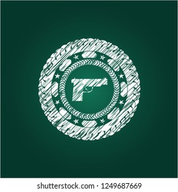 pistol icon inside chalk emblem written on a blackboard