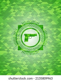 Pistolsymbol in grünem Emblem mit Mosaik-ökologischem Hintergrund. 