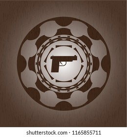 pistol icon inside retro style wooden emblem