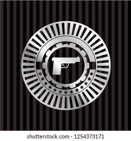 pistol icon inside silver emblem