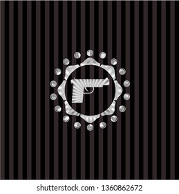 pistol icon inside silvery emblem or badge