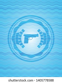 pistol icon inside sky blue water wave style badge.