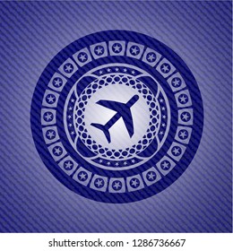 plane icon inside badge with denim texture