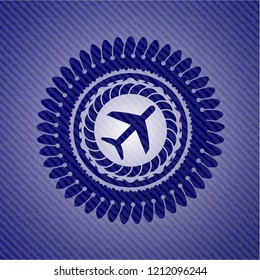 plane icon inside emblem with jean background