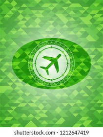 plane icon inside green emblem with triangle mosaic background