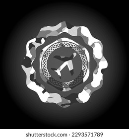 plane icon inside grey camouflaged emblem. 