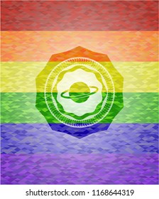 planet, saturn icon inside emblem on mosaic background with the colors of the LGBT flag