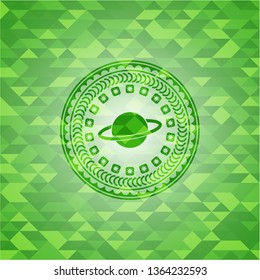 planet, saturn icon inside realistic green emblem. Mosaic background
