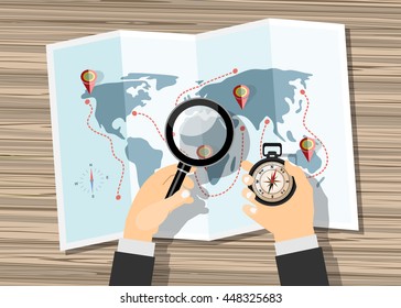 Planning trip concept at table with paper map of world, magnifier and compass.  Flat design style.