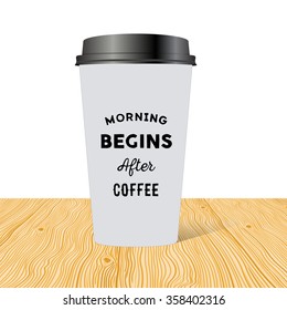Plastic cup of coffee with an inscription: Morning begins after coffee on wooden table.