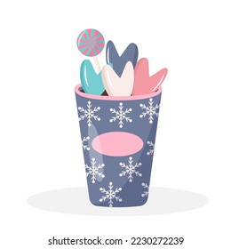 Plastic cup of coffee with snowflakes ornament, lollipop and sweet hearts. Hot winter drink isolated on white background.