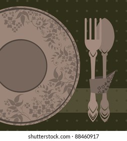 Plate, spoon and fork on a green background