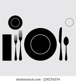 plate with spoon, knife and fork on a grey background