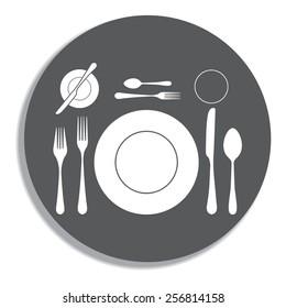 plate with spoon, knife and fork on a grey background