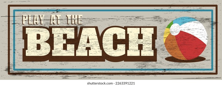 Play at the beach sign on wood grain