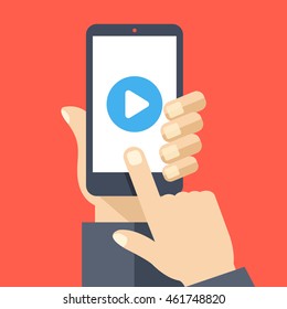 Play button on smartphone screen. Hand hold smartphone, finger touch screen. Watch video on mobile phone. Graphic concept for web banners, website, infographics. Modern flat design vector illustration