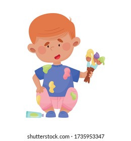 Niño juguetón con ropa manchada sentado y sosteniendo pinceles y pinturas ilustraciones vectoriales