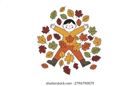 Playful happy young boy making a leaf angel while lying on the ground surrounded by colorful fallen autumn leaves.
