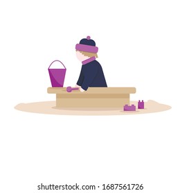 Сhild playing in the sandbox with a bucket and dice