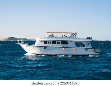 pleasure boat, yacht sailing on the blue sea with passengers.
