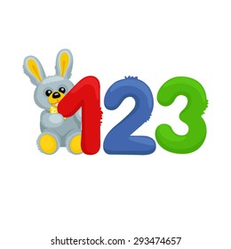 Plush bunny sitting near the numbers / The gray plush bunny sitting on the left of three numbers one, two, and three.
