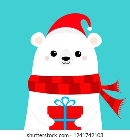 Polar white bear cub face holding gift box present. Red Santa hat, scarf. Cute cartoon baby character. Happy New Year. Merry Christmas. Arctic animal. Flat design Hello winter. Blue background. Vector