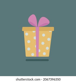 Caja de regalo de punto de polka con cinta rosa sobre fondo verde