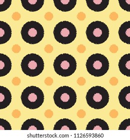 Polka dot seamless pattern with grunge shapes. Fashion circles in black, pink, orange colors on yellow background. Usable as print for textile, cover, wrapping paper etc.