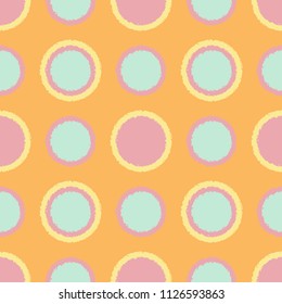 Polka dot seamless pattern with grunge shapes. Fashion circles in pink, mint green and yellow colors on orange background. Usable as print for textile, cover, wrapping paper etc.