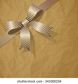 Polka Dots beige pearl ribbon on a crumpled paper brown background.