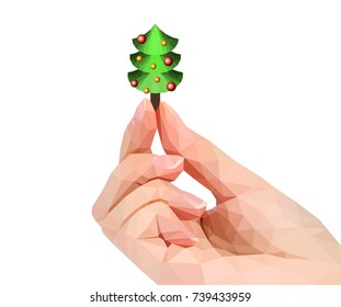 polygonal hand studio photo keeps Christmas tree in the fingers