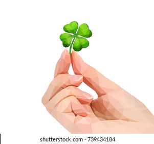 polygonal hand studio photo keeps four-leafed clover luck leprechaun in the fingers