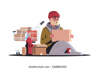 poor man with belongings in a trolley sitting on street begging for help beggar guy holding sign board homeless concept white background horizontal full length