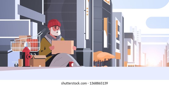 poor man with sitting on floor begging for help beggar guy holding sign board homeless concept modern city street buildings exterior sunset cityscape background horizontal full length