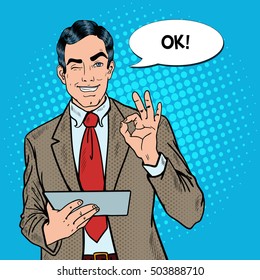 Pop Art Businessman with Tablet Gesturing OK and Winking. Vector illustration