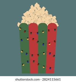 Popcorn in a festive red and green striped bucket with holiday string lights