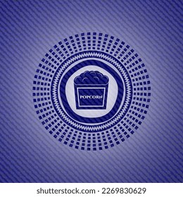 popcorn icon inside badge with denim texture. 